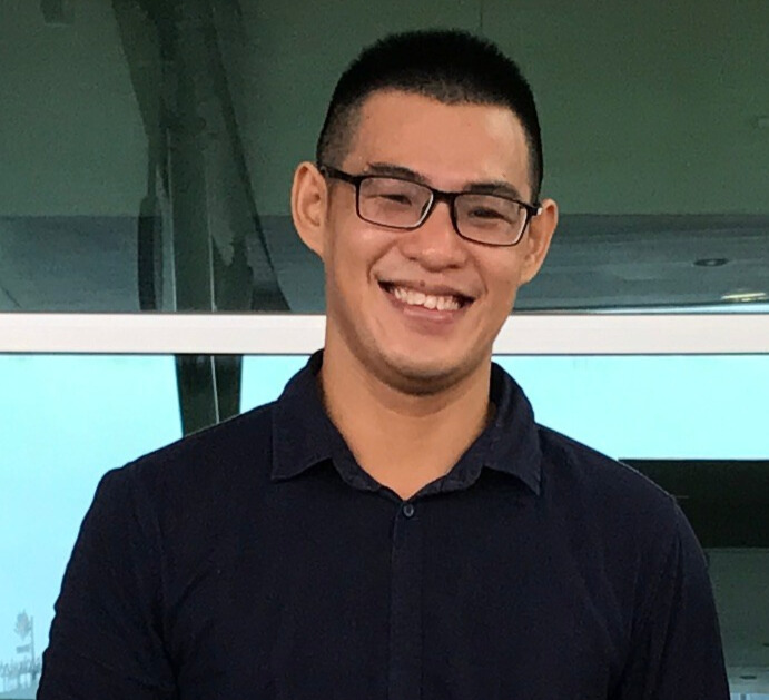 Hung Luong smiling in a dark collared shirt